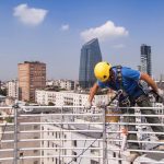 Lavori in quota in sicurezza Muratore su fune oltre parapetto