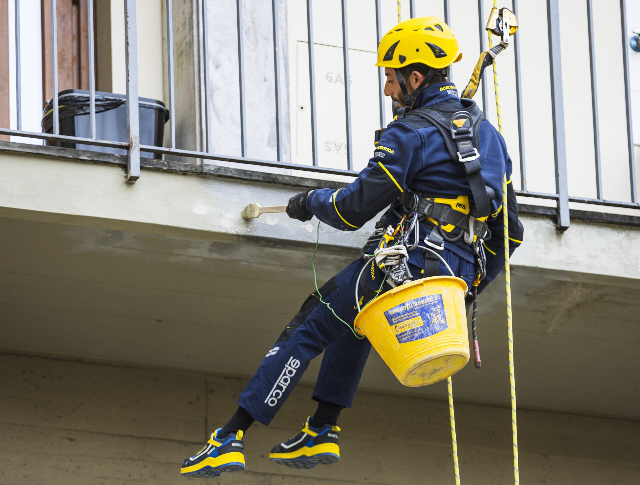Operaio di Acrobatica su fune durante un passaggio di intonacatura
