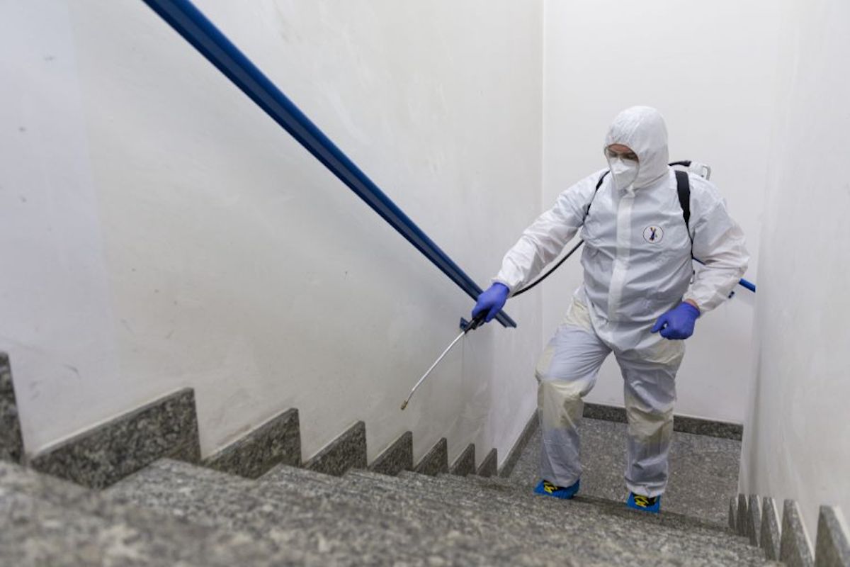 Sanificazione uffici. Foto di un'operaio durante la pulizia di un edificio.