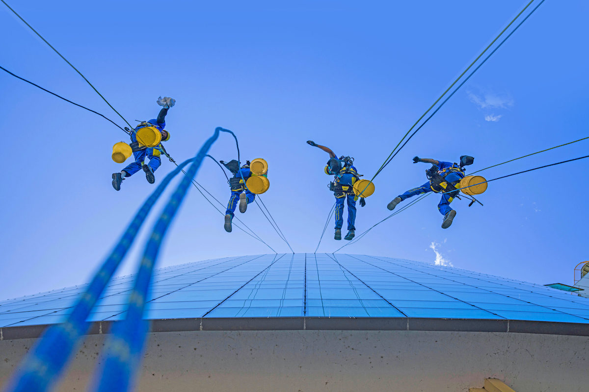 Acrobatica per i lavori che rientrano nell'ecobonus. Foto di una squadra su fune durante la risalita di un condominio.