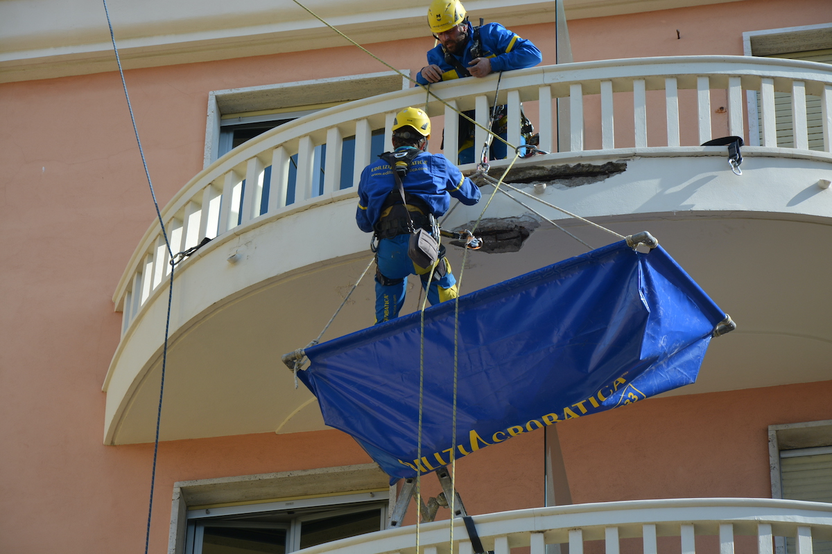 operai di acrobatica su balcone dell'hotel best western