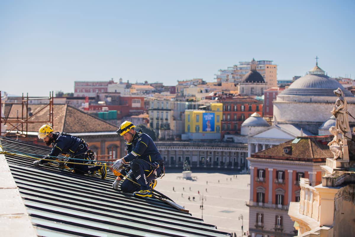 Come pulire la grondaia senza salire sul tetto: immagine di operaio Acrobatica su tetto