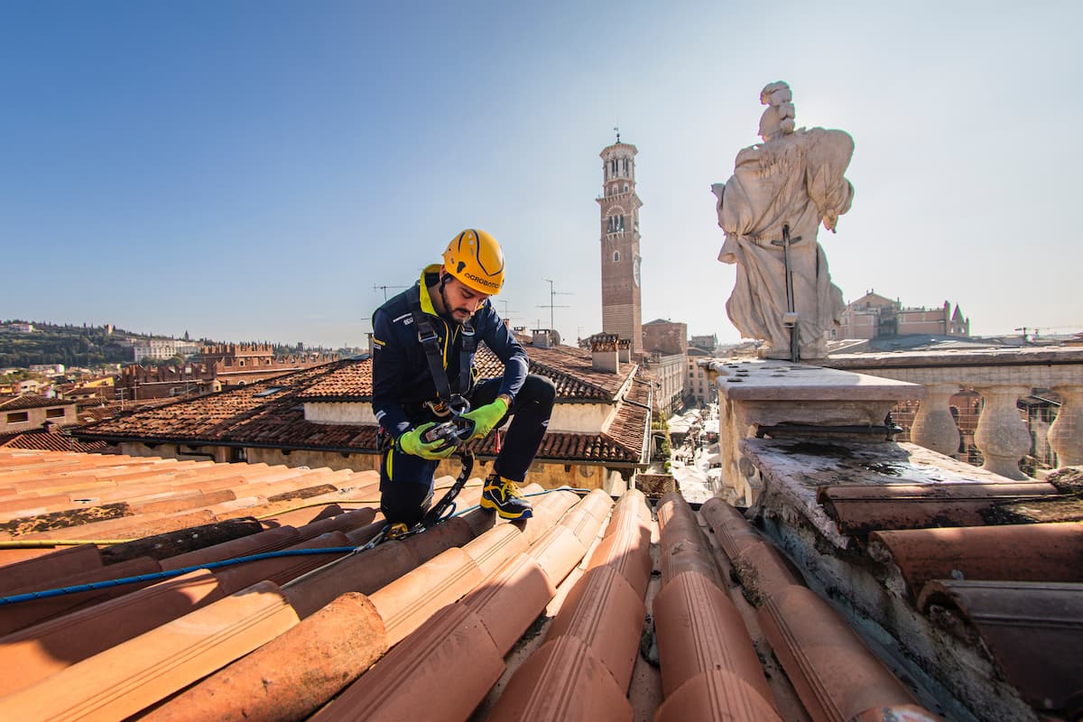 operaio acrobatica su tetto con sfondo palazzo vecchio a Firenze
