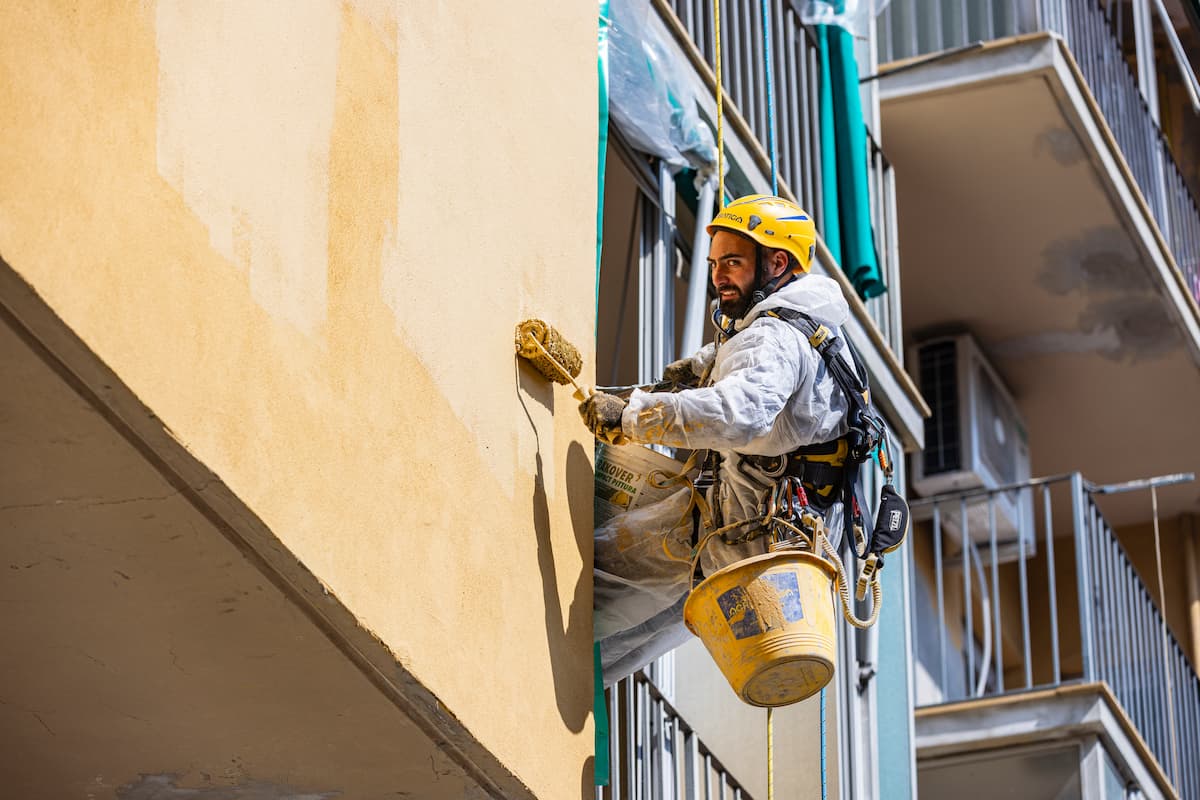 Esempi di intonaci speciali per interni: operaio su fune con rullo