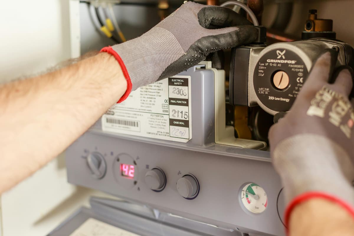dettaglio pompa di calore con mani di un tecnico