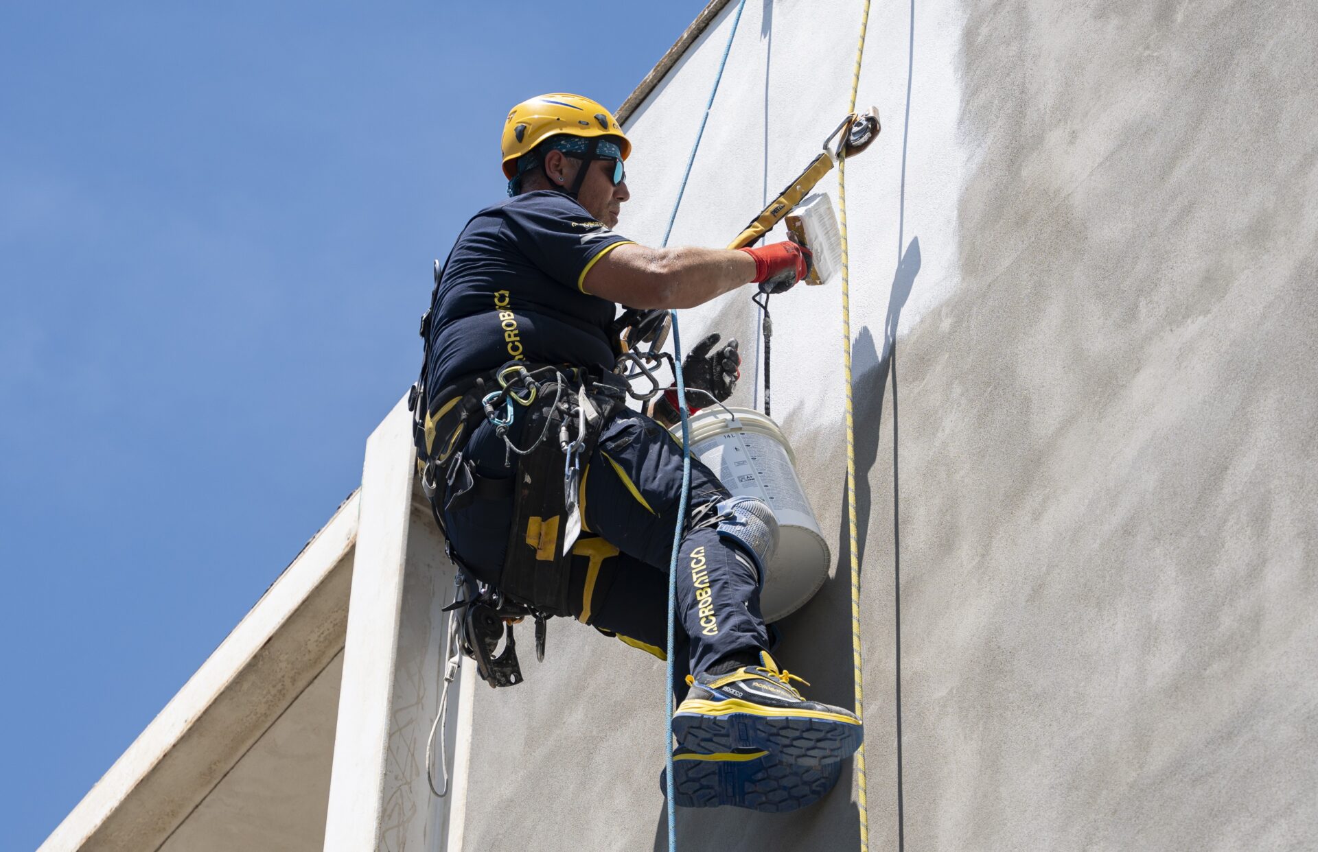 operaio acrobatica durante rifacimento facciata
